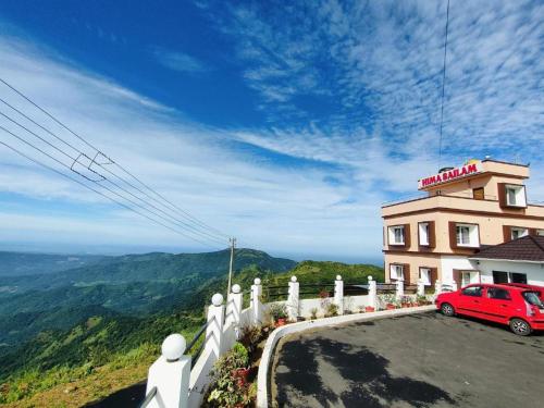 a red car parked in front of a building at Himasailam Resort in Vagamon