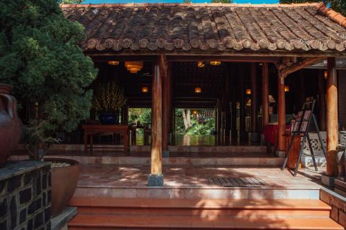 un bâtiment avec une terrasse couverte et un toit dans l'établissement Pilgrimage Village Boutique Resort & Spa, à Hue