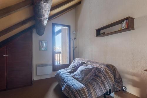 um quarto com uma cama e uma janela em Les Chardons - Apt duplex vue montagne em Saint-Léger-les-Mélèzes