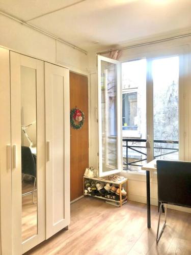 un salon avec une grande fenêtre et une table dans l'établissement Enchanting Retreat in the Heart of the Latin Quarter - Entire Studio for yourself, à Paris