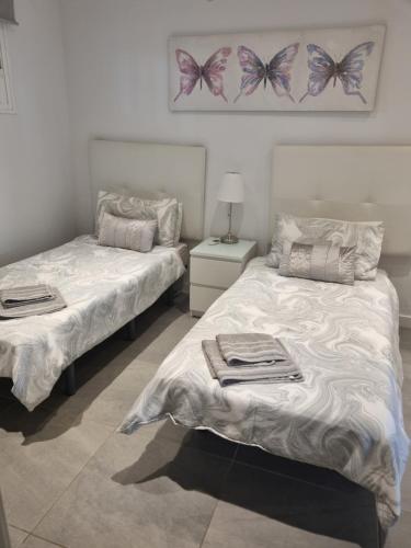 two beds in a room with butterflies on the wall at Lazydays in Puerto del Carmen