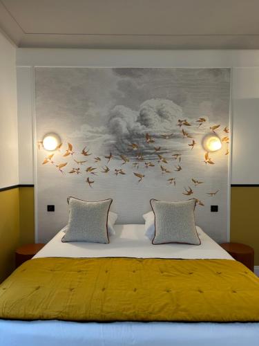 a bedroom with a large bed with birds flying at Le Grand Hôtel Mont Dore in Le Mont-Dore