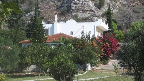 una casa bianca con una montagna sullo sfondo di Villa Dunes 350m from the sandy beach a Kalogria