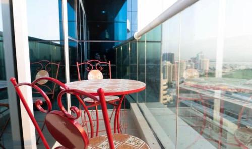 a red table and chairs on a balcony at Global golf residency 2, sports city in Dubai