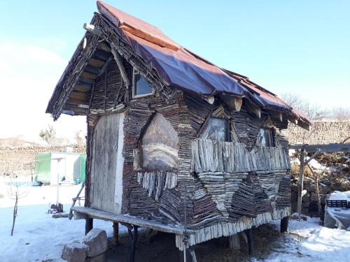 a house made out of wood with a rusty roof at Gezginlerin Evi in Talas
