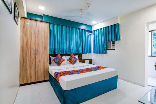 FabExpress Bindra Elite في مومباي: غرفة نوم بسرير كبير مع ستائر زرقاء