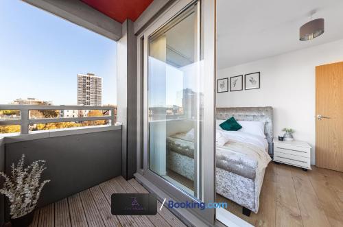 a bedroom with a balcony with a bed and a window at Two Bedroom Flat By Zen Abodes Short Lets & Serviced Accommodation with Free Wifi & TV Close to Old St in London