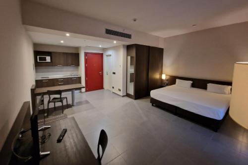 um grande quarto de hotel com uma cama e uma secretária em Inn Naples Airport em Gricignano dʼAversa