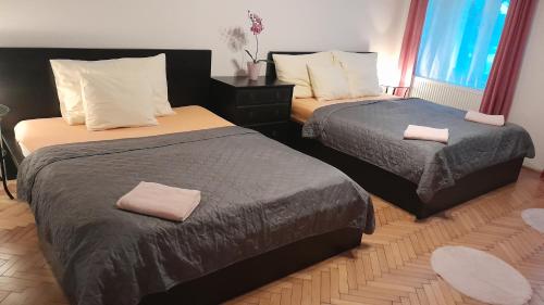 Dos camas en una habitación de hotel con toallas encima. en Family Flat 120m2, Praha 2 Vinohrady, en Praga