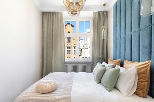 a bedroom with a large bed with a window at Elite Apartments Mariacka Premium in Gdańsk