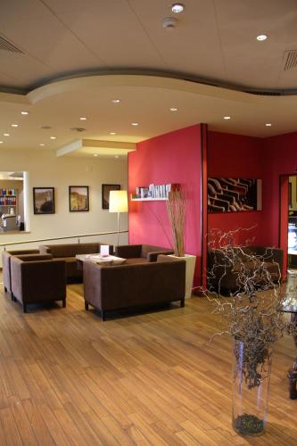 a lobby with couches and a red wall at Enjoy 1313AG Hotel Touring in Chiasso