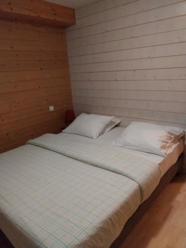 a bedroom with two beds in a wooden wall at Les Adrets in Gérardmer