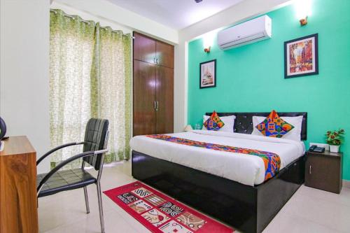a bedroom with a bed and a chair in a room at Aruba Suites in Noida