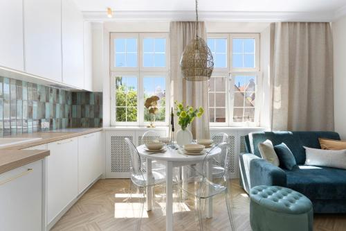 a kitchen and living room with a table and chairs at Elite Apartments Mariacka Premium in Gdańsk