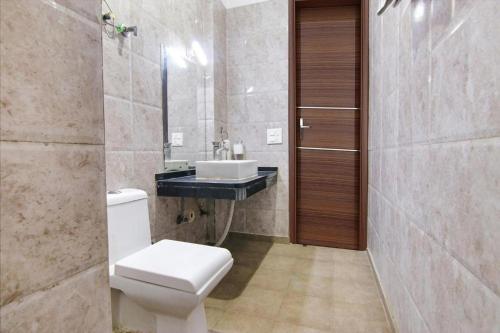 a bathroom with a toilet and a sink at Aruba Suites in Noida