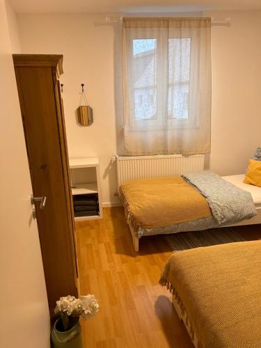 a bedroom with two beds and a window at Ländliche Fewo Rose, 4km zum Stausee in Happurg