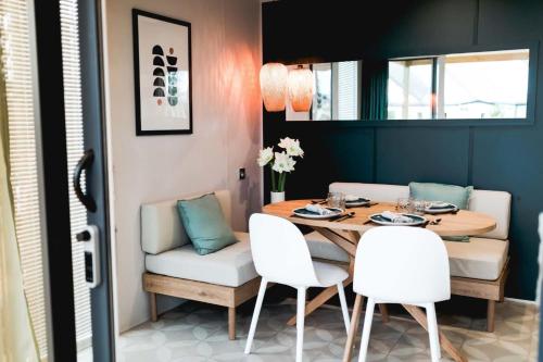 une salle à manger avec une table et des chaises blanches dans l'établissement Mobil Homes Vacances, à Grimaud