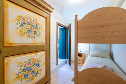una camera con letto a castello in legno e un ingresso di Asiago Centro - Comodissimo Appartamento al Piano Terra ad Asiago