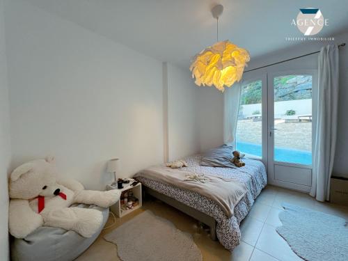 une chambre avec un ours en peluche assis sur un lit dans l'établissement Villa 6 personnes avec piscine privée, à Sainte-Maxime