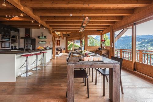 a kitchen and dining room with a large wooden table at Chalet Omaroo Morzine - by EMERALD STAY in Morzine