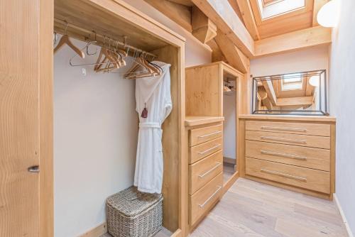 a small closet with wooden cabinets and a mirror at Chalet Omaroo Morzine - by EMERALD STAY in Morzine