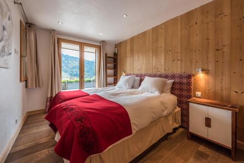 a bedroom with a large bed and a window at Chalet Omaroo Morzine - by EMERALD STAY in Morzine