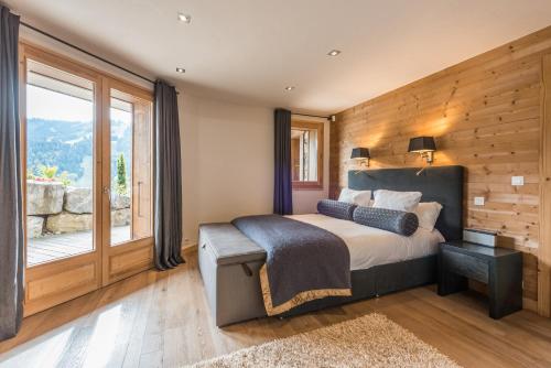 a bedroom with a large bed and a window at Chalet Omaroo Morzine - by EMERALD STAY in Morzine