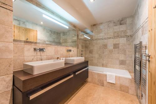 a bathroom with a sink and a tub at Chalet Omaroo Morzine - by EMERALD STAY in Morzine