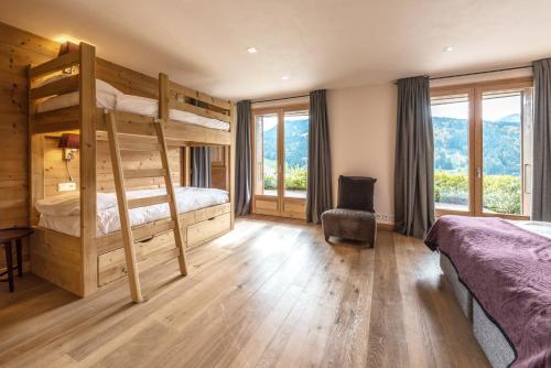 a bedroom with two bunk beds and a desk at Chalet Omaroo Morzine - by EMERALD STAY in Morzine