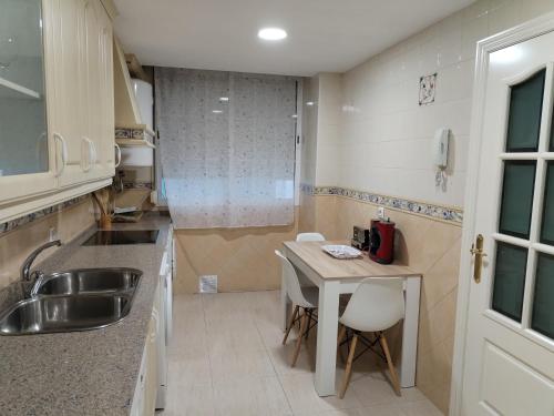 une petite cuisine avec un évier et une table dans l'établissement Apartamento con PARKING PRIVADO GRATIS INCLUIDO, à Cordoue