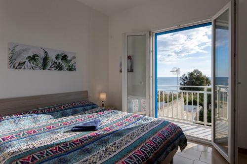 a bedroom with a bed and a view of the ocean at Onde in Triscina