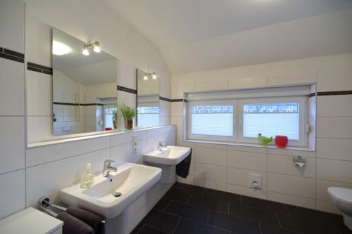 a bathroom with a sink and a toilet and a mirror at Ferienhaus Auszeit in Borkum