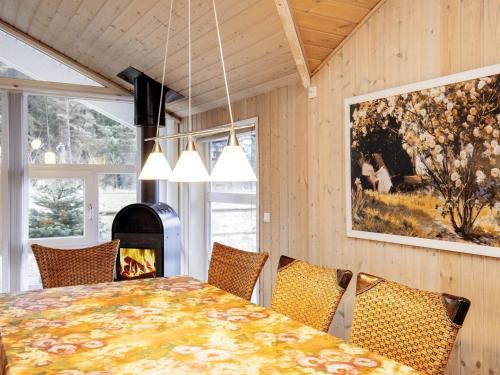 ロッケンにあるThree-Bedroom Holiday home in Løkken 81のダイニングルーム(テーブル、暖炉付)