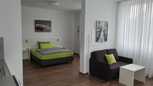 a bedroom with a bed and a couch and a chair at Neckarzeit in Neckarwestheim
