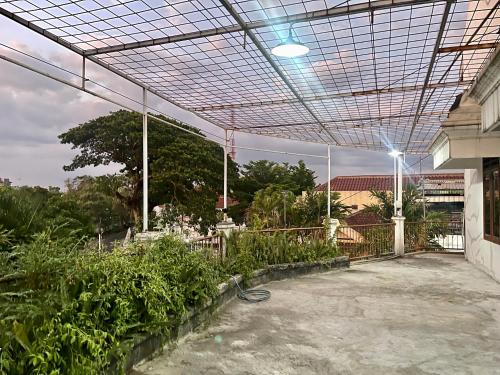 an outdoor patio with a greenhouse with plants at Telu.Telu Solo in Solo