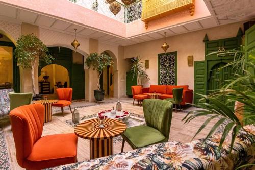 una hall con tavoli e sedie arancioni e verdi di Riad contessa a Marrakech