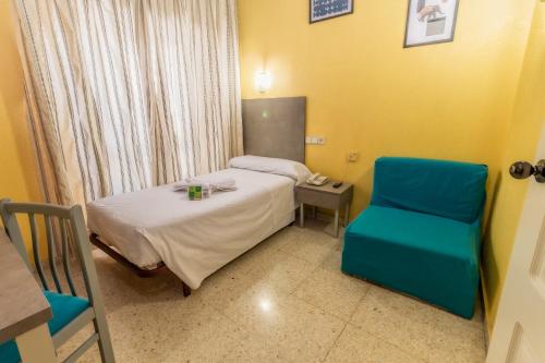 a hospital room with a bed and a blue chair at Hotel Universal Murcia in Murcia
