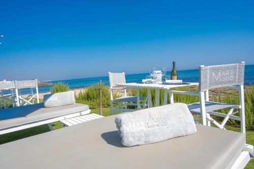 een tafel en stoelen met de oceaan op de achtergrond bij La Maison di Paola in Ostuni