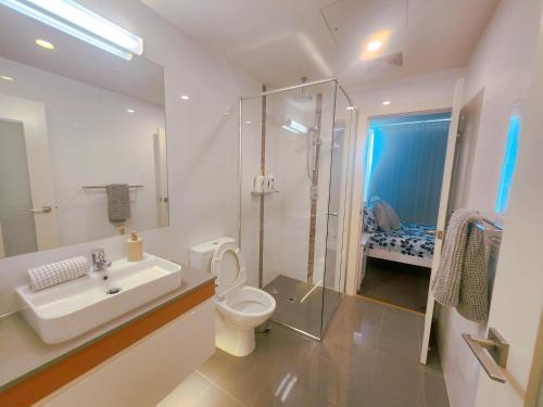 La salle de bains est pourvue d'un lavabo, de toilettes et d'une douche. dans l'établissement TAO—Rowlands 黑桃睡梦馆——罗兰, à Adélaïde