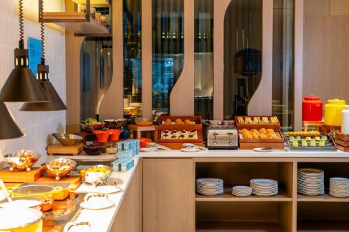 a buffet line with plates and fruit on display at Holiday Inn Express Suzhou Bay by IHG in Suzhou