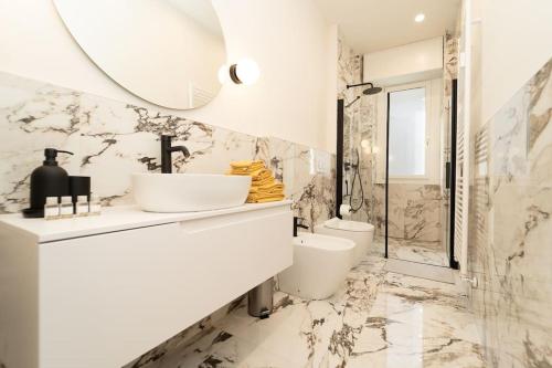 a bathroom with a sink and a toilet and a mirror at Esclusivo appartamento con 2 camere da letto in Milan