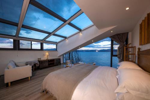 a bedroom with a large bed and a large window at Dali Beauty Seaview B&B in Dali