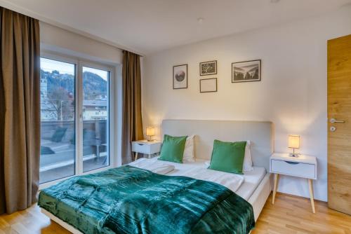 a bedroom with a large bed with green pillows at NA-Home Kitzbühel Tristkogel in Kitzbühel
