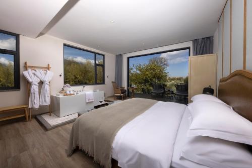 a bedroom with a large bed and large windows at Dali Beauty Seaview B&B in Dali