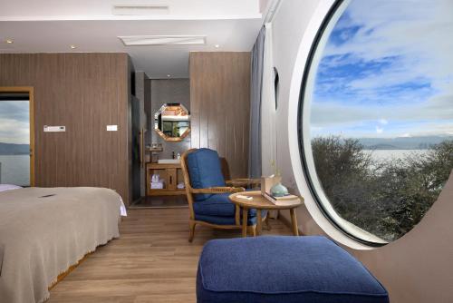 a bedroom with a large window with a bed and a table at Dali Beauty Seaview B&B in Dali