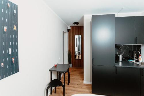 a kitchen with a table and a black refrigerator at Cosy Central Studio Apt. - Near Old Town in Riga