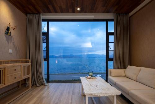 a living room with a couch and a large window at Dali Beauty Seaview B&B in Dali