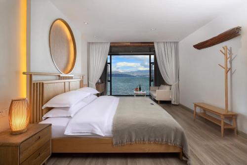 a bedroom with a large bed with a large window at Dali Beauty Seaview B&B in Dali