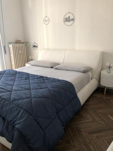 1 dormitorio con 1 cama grande y edredón azul en Holly's House apartment, en Alzano Lombardo
