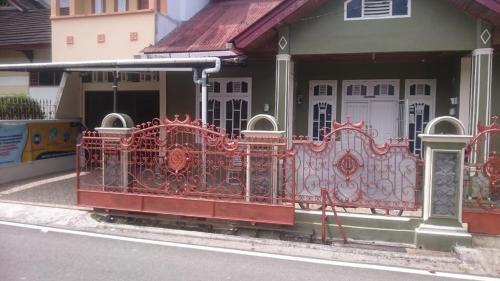 una recinzione rossa sul lato di un edificio di KHAIRI HOMESTAY a Bukittinggi